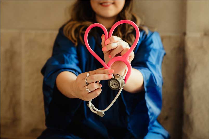 Infirimiere faisant un coeur avec un stéthoscope
